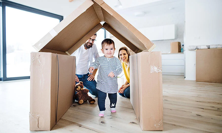Image Of First-Time Home Buyers Sending Their Child Through A Packing-Box Fort