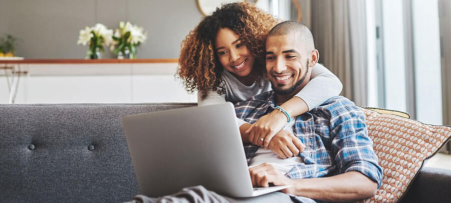First-time home buyers looking at properties on a non-branded laptop and sincerely enjoying each other's company which is heart-warming to me and probably you as well they look so happy