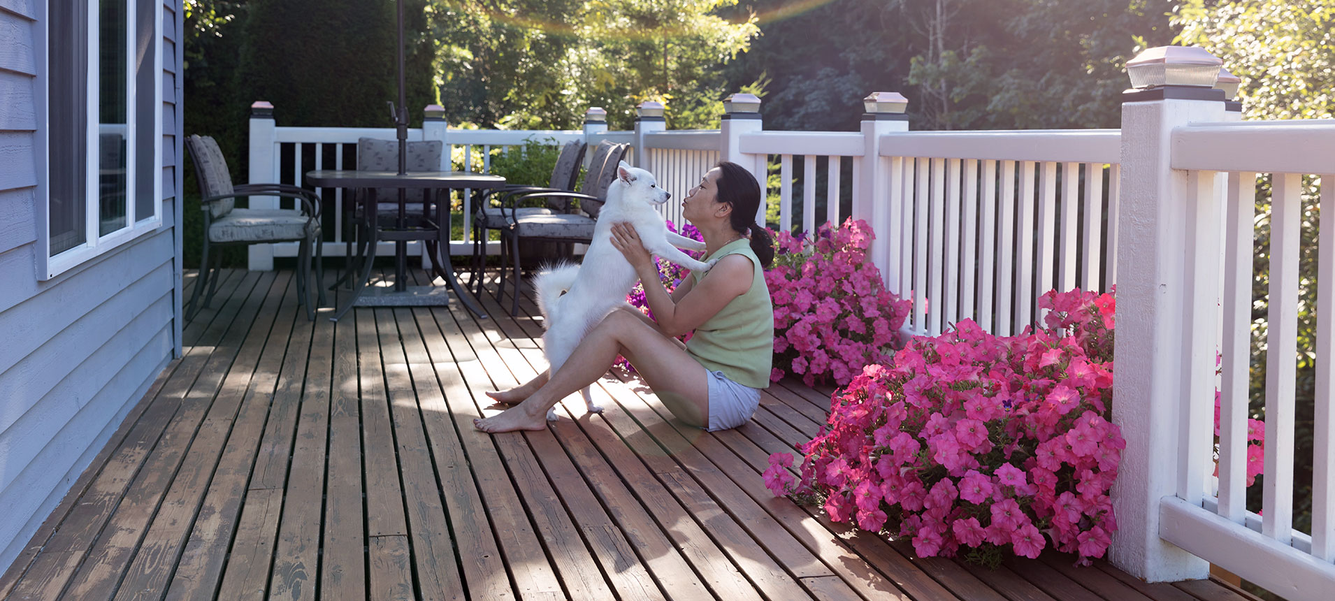 A First-Time Home Buyer And Her Dog Sitting In Pink Flowers, Playing The Mortgage Abbreviations Game